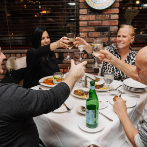 table of people enjoying drinks and food