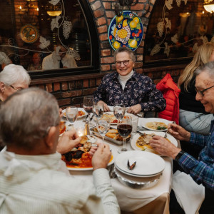 table of people enjoying drinks and food