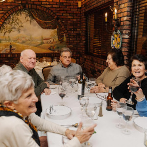 table of people enjoying drinks and food