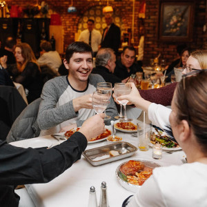table of people enjoying drinks and food