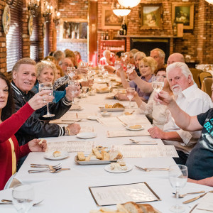 big table of ppl cheersing glasses